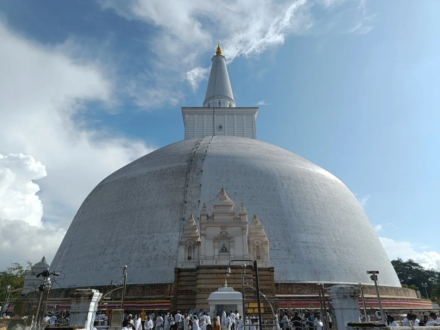 A monumental white stupa in Anuradhapura beneath a blue sky