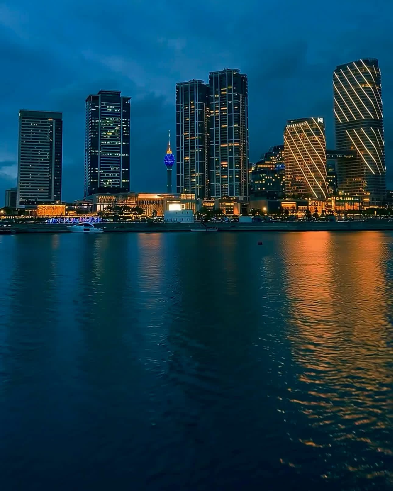 Colombo's modern skyline reflected in the water after sunset