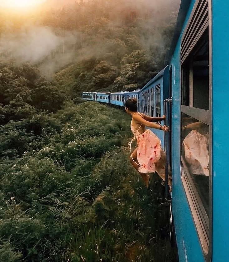 Blue train travelling through Sri Lanka's misty hill country